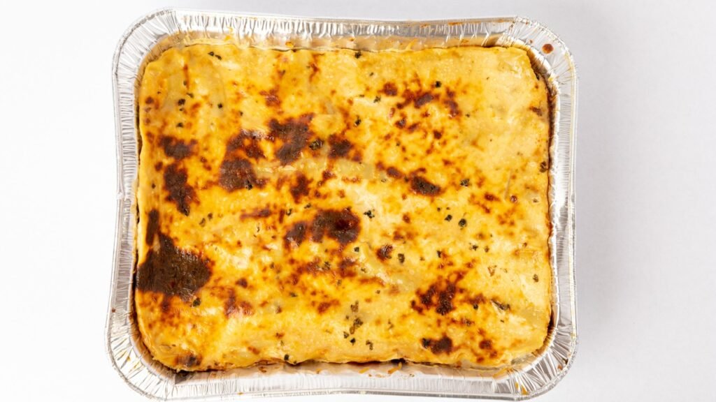 Profissional usando notebook com painéis de dados e interface digital, para o artigo Escondidinho de Carne Seca com Purê d...