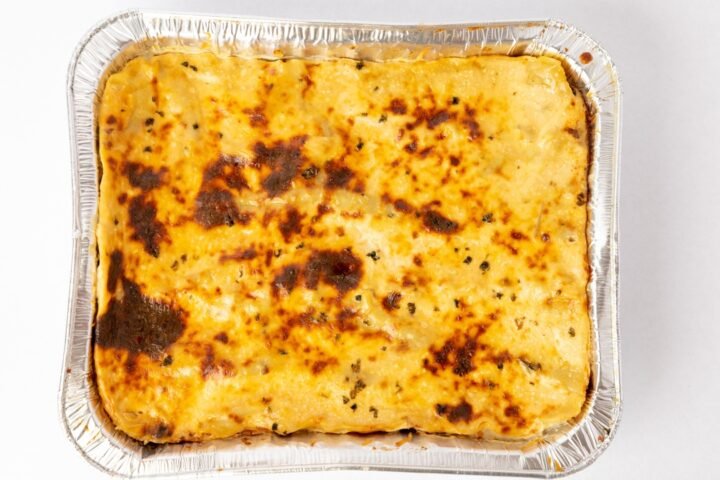 Profissional usando notebook com painéis de dados e interface digital, para o artigo Escondidinho de Carne Seca com Purê d...